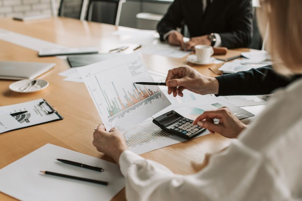 pexels photo 7433837 Professionals reviewing financial graphs and charts during a meeting.